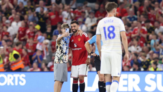 Pitch invaders take selfies with Fernandes during Man United match United